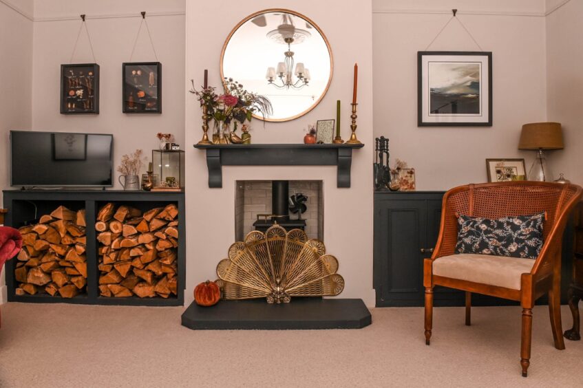 The living room in the period property in Aberdeen, with a woodburning fireplace, an alcove full of chopped wood and stylish decor