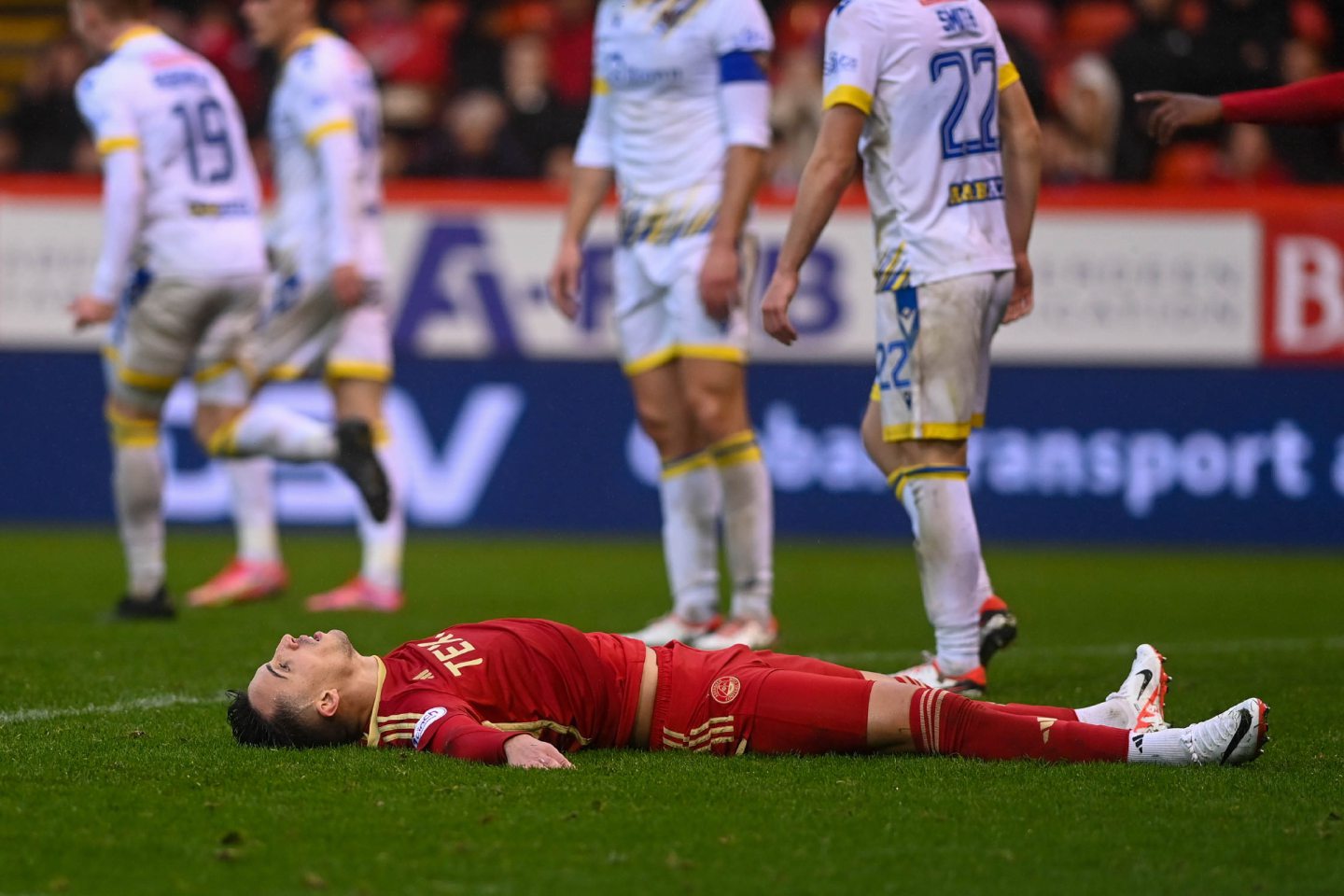 Aberdeen's Bojan Miovski lying down on the pitch, looking dejected