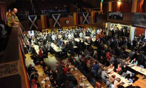 Elgin Town Hall full with Scottish and German flags hanging from balcony.