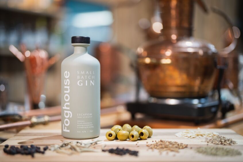 A bottle of Foghouse Gin with some olives next to it