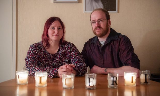 Jade and Gary Archibald, of Elgin. 'We were just burnt out and couldn't do it anymore,' said Jade. Each of the seven candles represents a lost embryo. Image: Jason Hedges/DC Thomson
