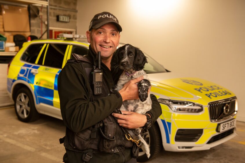 PC Steve Warden holding Dee the Sprocker spaniel 