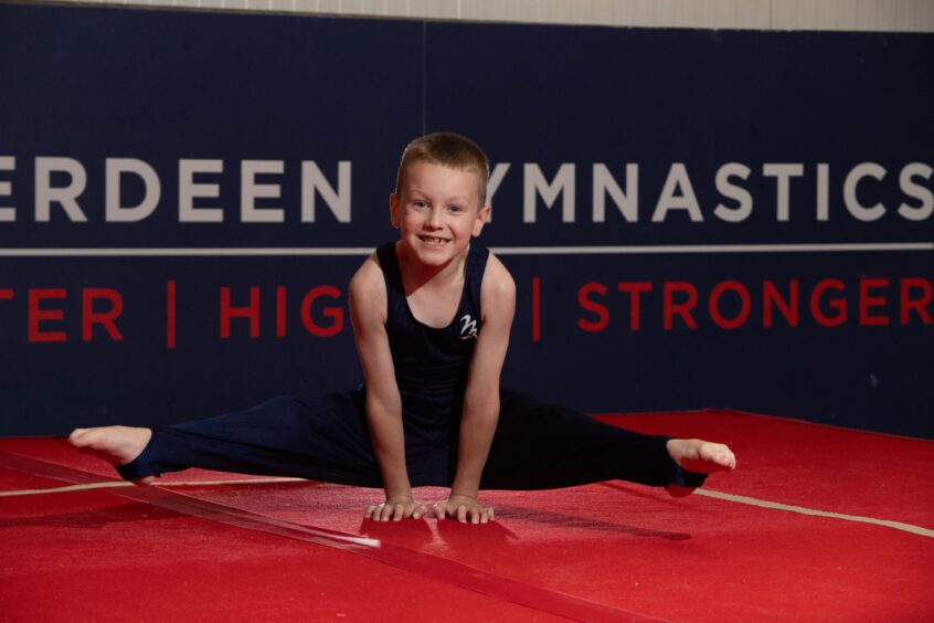 The 7-year-old Aberdeen gymnast performs a straddle l-sit.