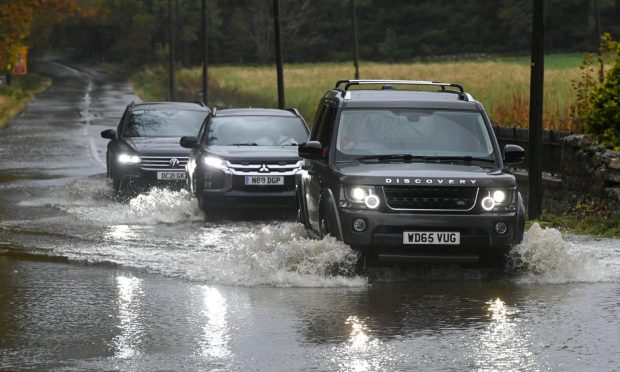 Cars driving through flooded water in Aberdeenshire.