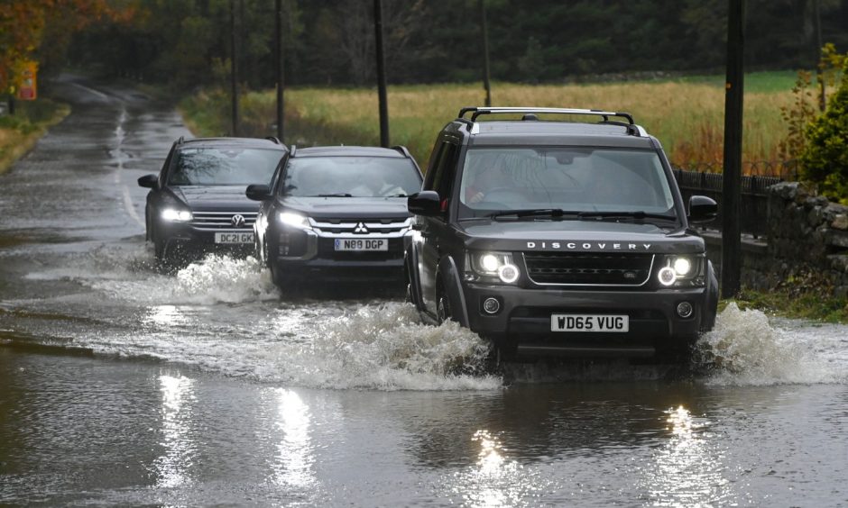 Cars going through water on the A944 Westhill to Dunect road after Storm Babet.