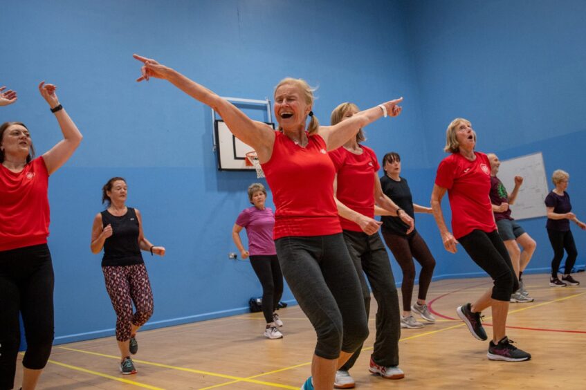 Christina leading the Aberdeen Friskis and Svettis class with her hands in the air and a wide smile on her face