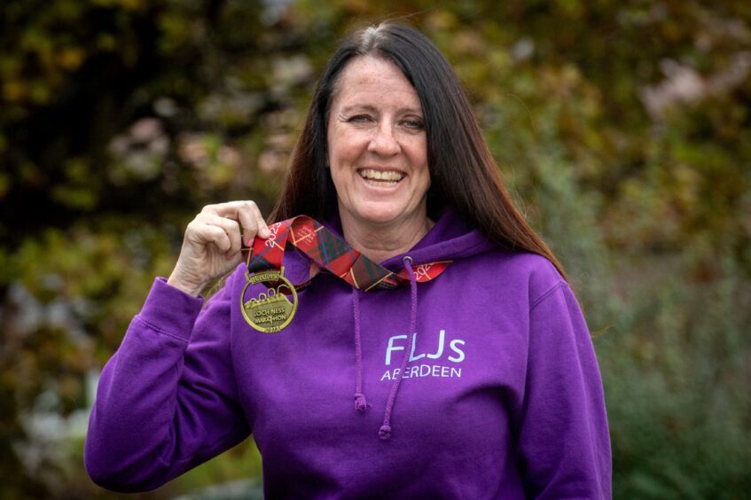Aberdeen gran Linda Dawson smiles with the medal she earned at the Loch Ness Marathon.