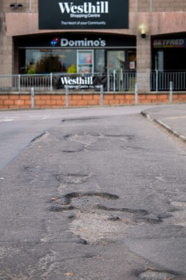 Potholes on the road at Westhill Shopping Centre.