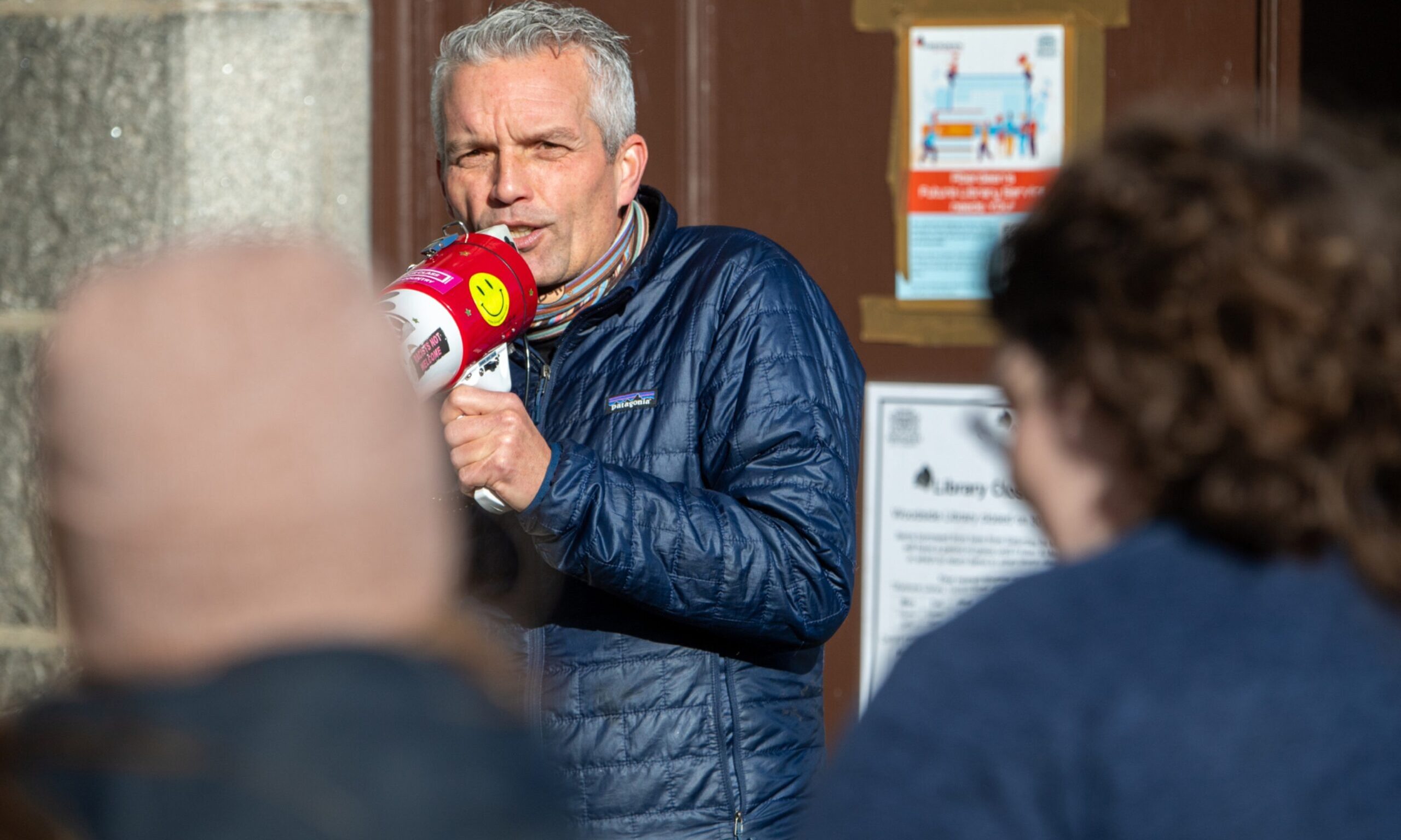 Hayden Lorimer holding a megaphone speaking to people.