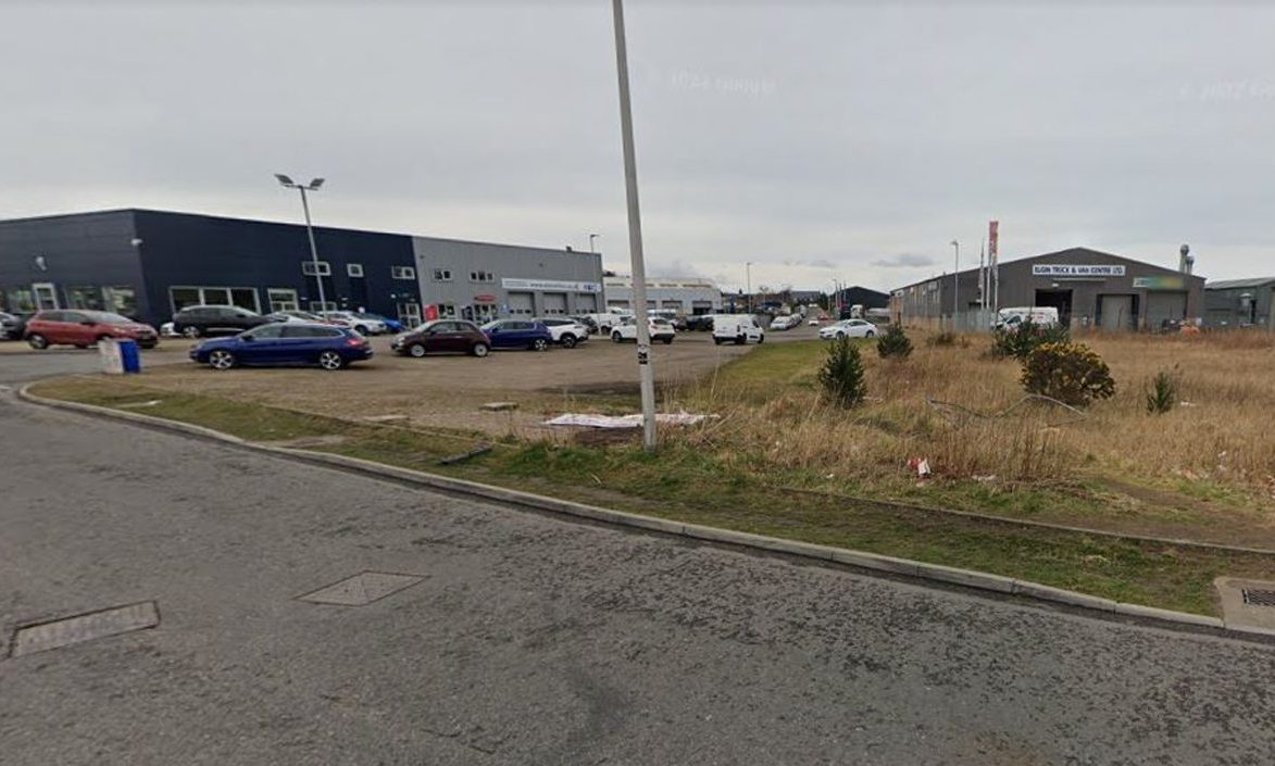 Google Maps image of barren ground near car dealership. 