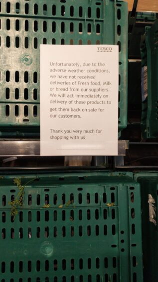 Sign on fresh produce aisle at Tesco supermarket in Aberdeenshire that reads: 'Unfortunately, due to the adverse weather conditions, we have not received deliveries of fresh food, milk or bread from our suppliers. We will act immediately on delivery of these products to get them back on sale for our customers. Thank you very much for shopping with us.'