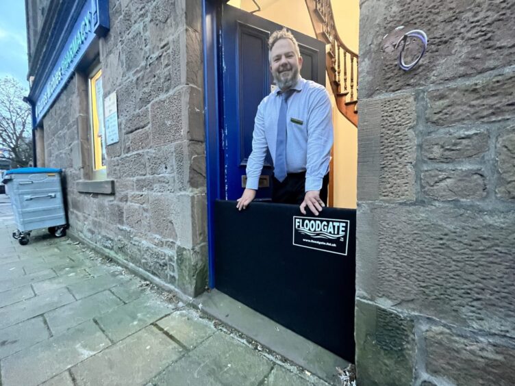 Man standing outside Charles Michie's Pharmacy in Stonehaven.