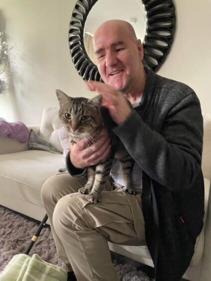 Tam Ferris with Misha the Oban cat that was discovered in Aberdeen.