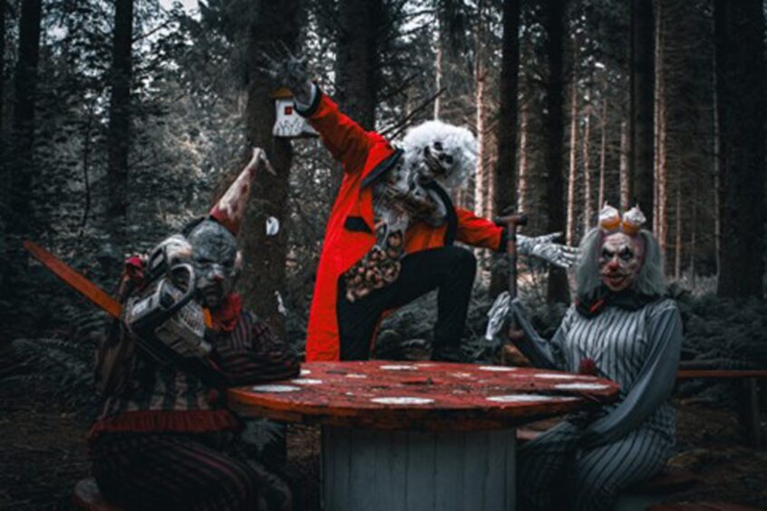 Actors posing in creepy costumes in the woods.