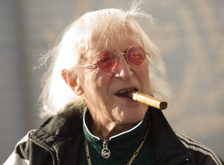 Disgraced children's TV presenter Jimmy Savile with a trademark cigar.