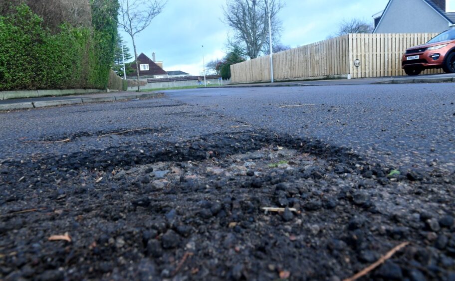 Potholes - like this in Burnieboozle Crescent - could be left unrepaired for much longer. Image: Chris Sumner/DC Thomson