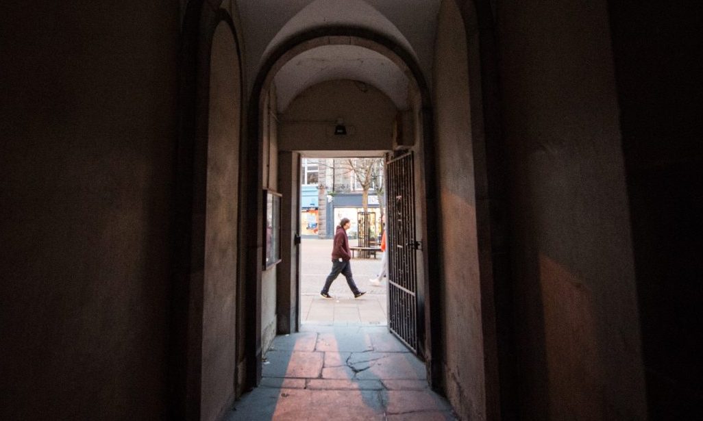 Looking down dark alley into light of Elgin town centre. 