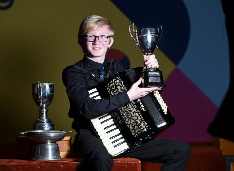 Fraser Donaldson of Charleston Academy, Inverness with the Fergie MacDonald Trophy as an aggregate in the under 13 accordion competitions.