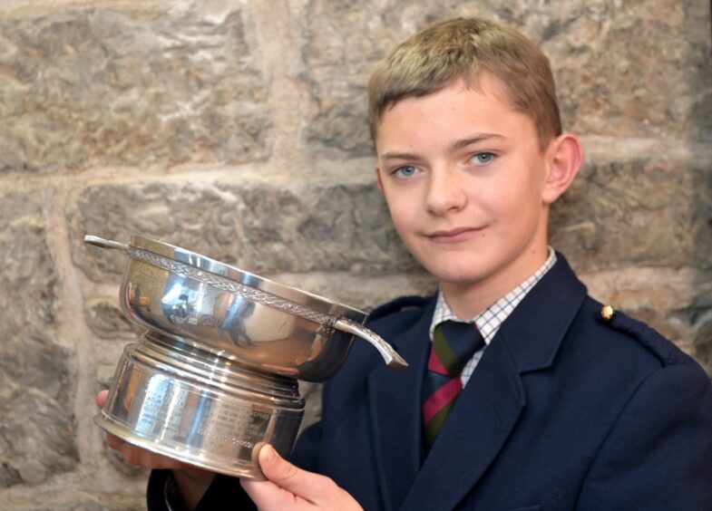 Callan Erskine of Bertha Park with the DR DS MacLaggan Memorial Trophy for Piobaireachd under 16, received at the Mod.