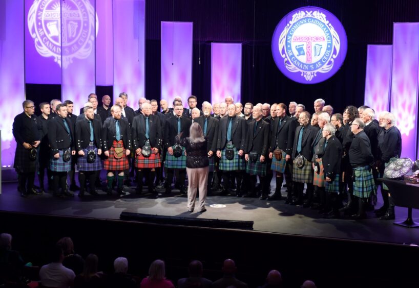 Nina MacKellar conducts a mass male voice choir in Paisley Town Hall with a composition by and in tribute to the late Kirsteen Menzies who died recently. 