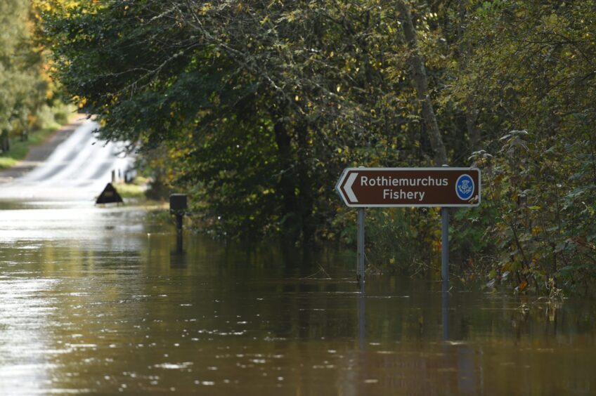 Flood water rises up a signpost as the River Spey burst its banks.
