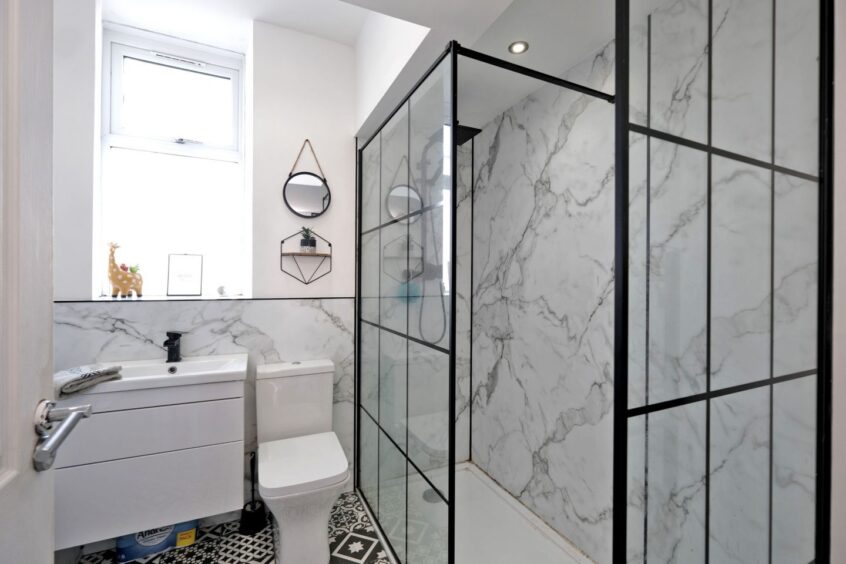 The upgraded bathroom within the Aberdeen property, featuring a large walk-in shower with rainfall and handheld facilities.