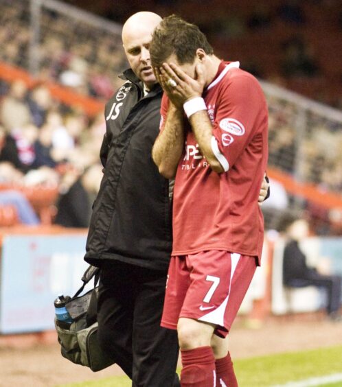 Jamie Smith goes off injured with former Aberdeen medic John Sharp during a game in October 2007