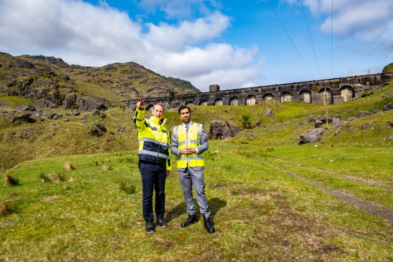 Humza Yousaf at SSE Sloy Announcement standing in a field wearing yellow vest.