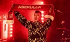 A member of Skylights holding an Aberdeen FC scarf on stage