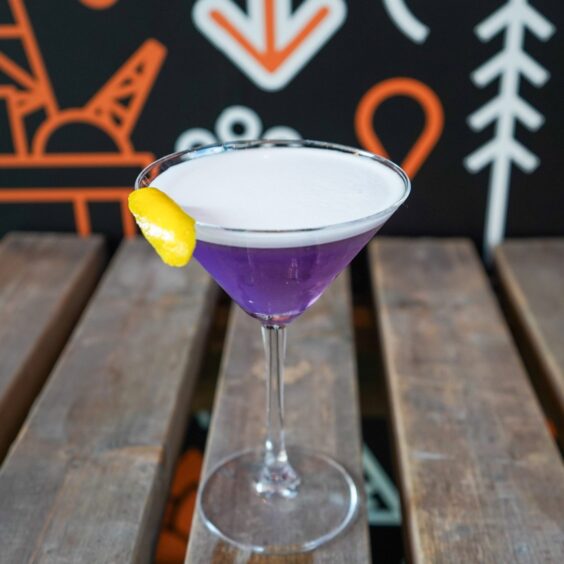 The Sapphire, a purple drink with a portion of lemon hanging from the glass