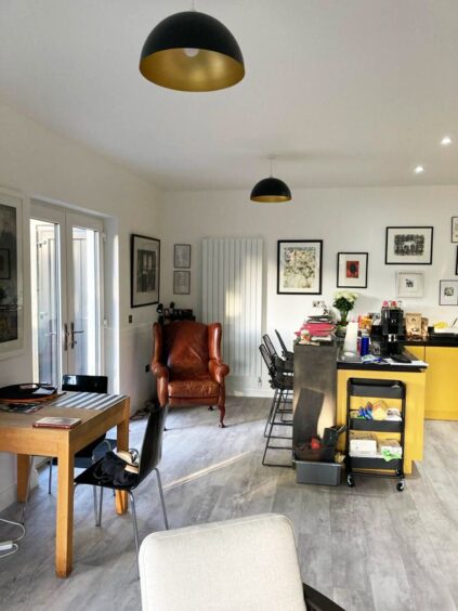 The open plan kitchen of the new build in inverness with a living chair in the corner and a desk up against the wall
