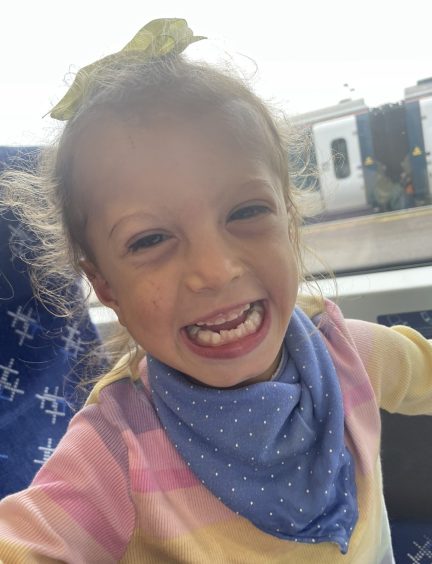 Georgia Hill smiling at the camera on a train in Aberdeen