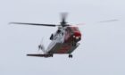 Coastguard helicopter in the air.