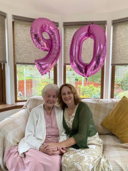 Elma O'Rourke and her daughter Melanie Brennan with 90th birthday balloons behind them