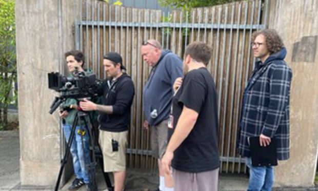 James Rose (right) stands behind a camera with other members of the crew on the set of 'A Song for Gran.