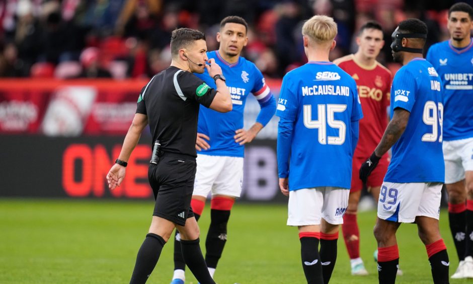 Nick Walsh blows his whistle on the pitch before going to the VAR monitor to check for a possible penalty kick to Rangers against Aberdeen
