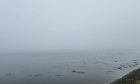 Thick fog covers the Beauly Firth, concealing the Kessock Bridge from view.