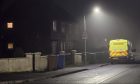 A yellow police van sits outside a property in the Dalneigh area of Inverness where an investigation is ongoing into the sudden death of a man