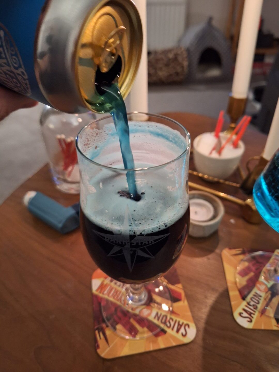 The blue beer being poured into a glass, showing the striking colour mid-flow. 