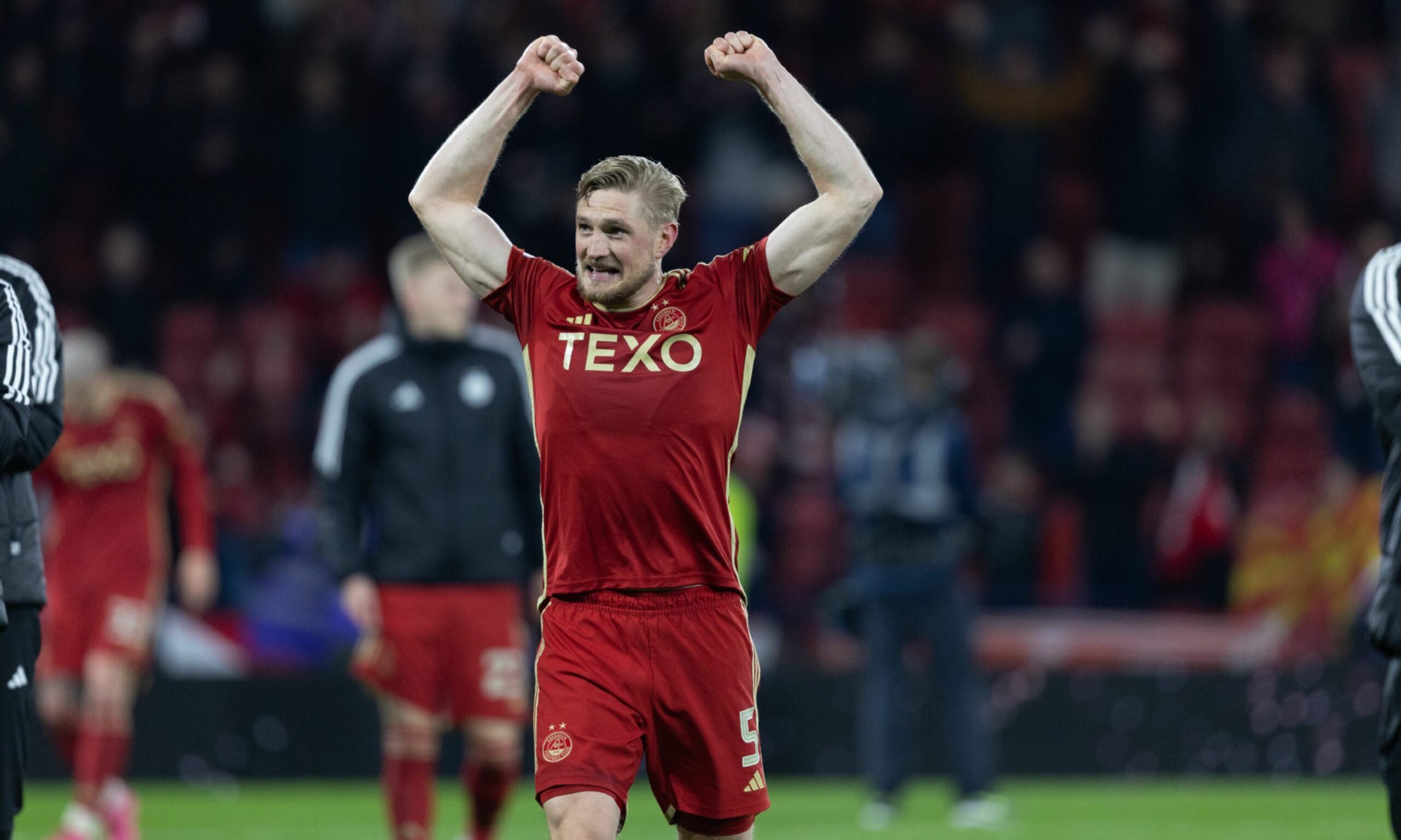 Richard Jensen celebrating on the pitch with his arms in the air