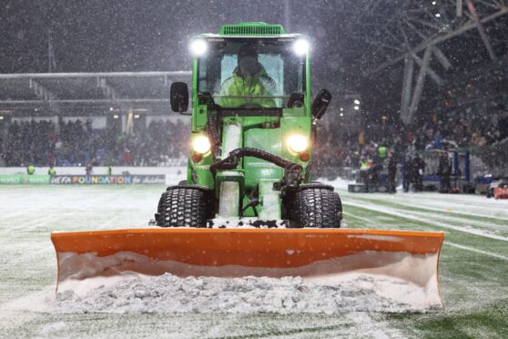 A tractor clears snow off the pitch during a delay in the second half at the Bolt Arena. Image: SNS