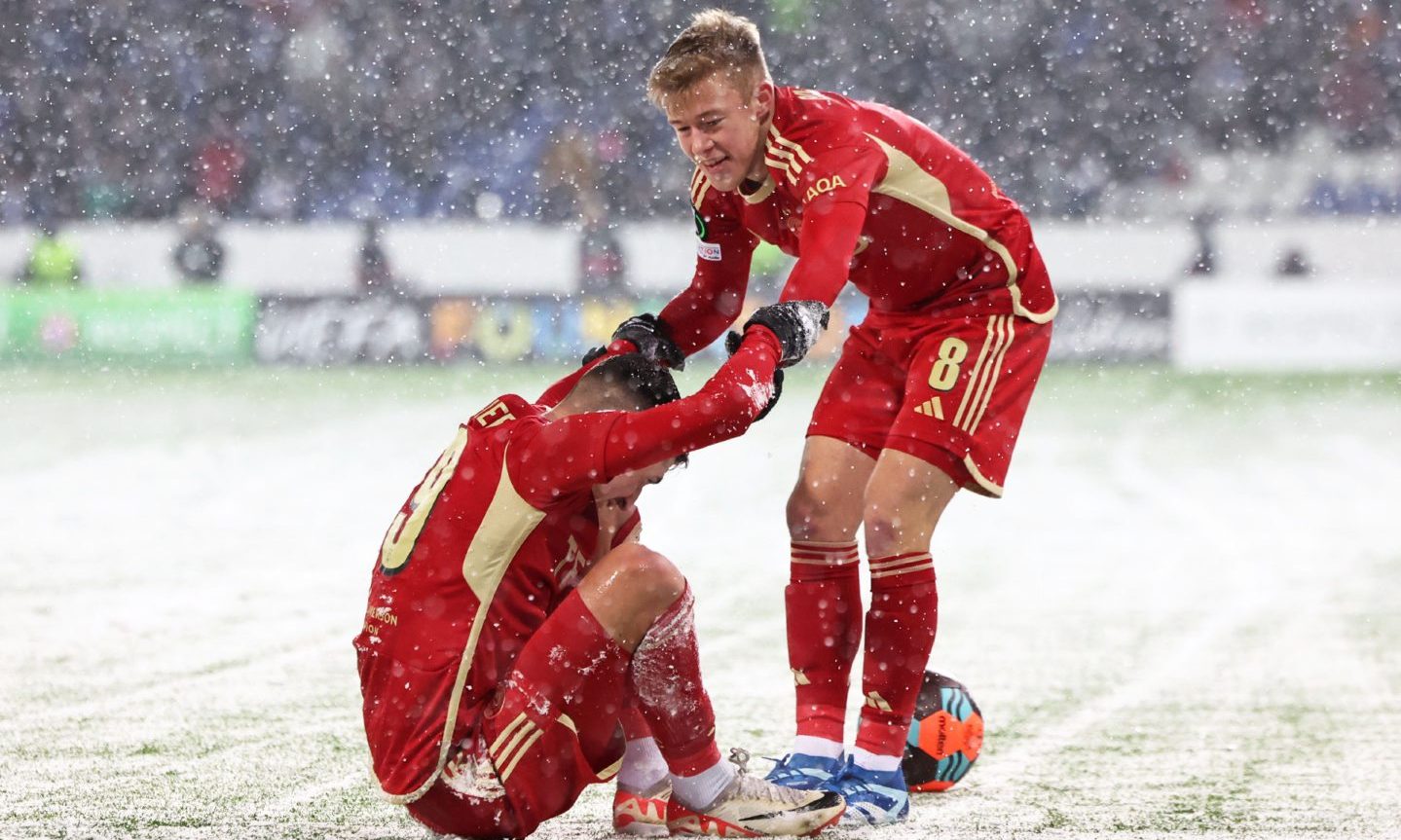 Aberdeen's Connor Barron helps his team mate Ester Sokler in the snow