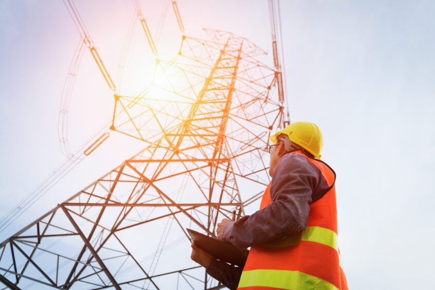 Engineer working on high-voltage power lines.