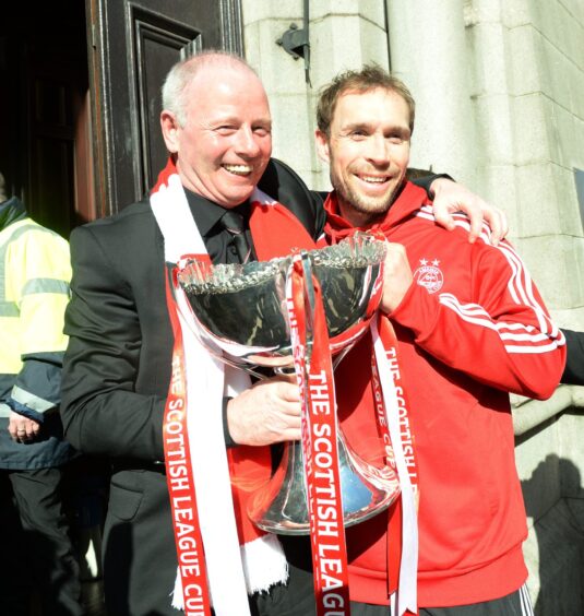 Former Aberdeen chairman Stewart Milne (left) embraced then club captain Russell Anderson as the Scottish League Cup arrived at the Town House in 2014.