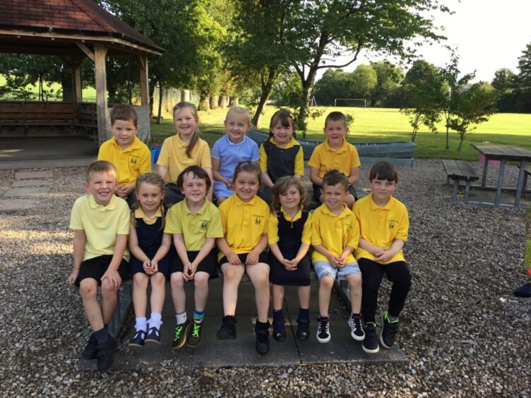 First class of 2023 at Alves Primary School in Moray sitting in two rows in a playground