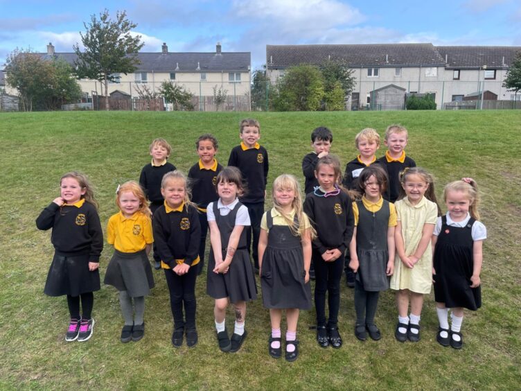 First class of 2023 at Ardersier Primary in the highlands and islands. The children are standing in two rows on the grass outside