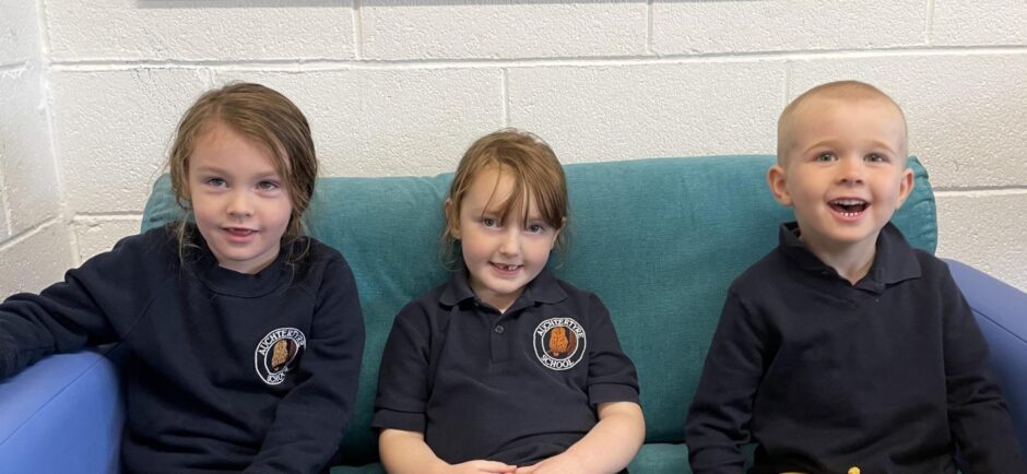 Three Auchtertyre Primary pupils sitting on a couch