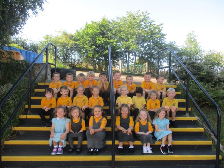 First class of 2023 at Balloch Primary School in the highlands and islands, sitting in rows on a set of stairs outside