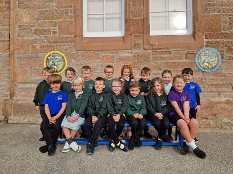 First class of 2023 at Beauly Primary School in the highland and islands sitting in two rows outside the school