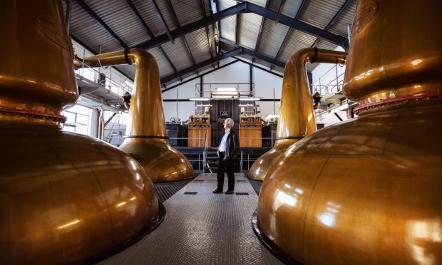 Billy Walker, owner, between the four copper stills at The GlenAllachie Distillery.